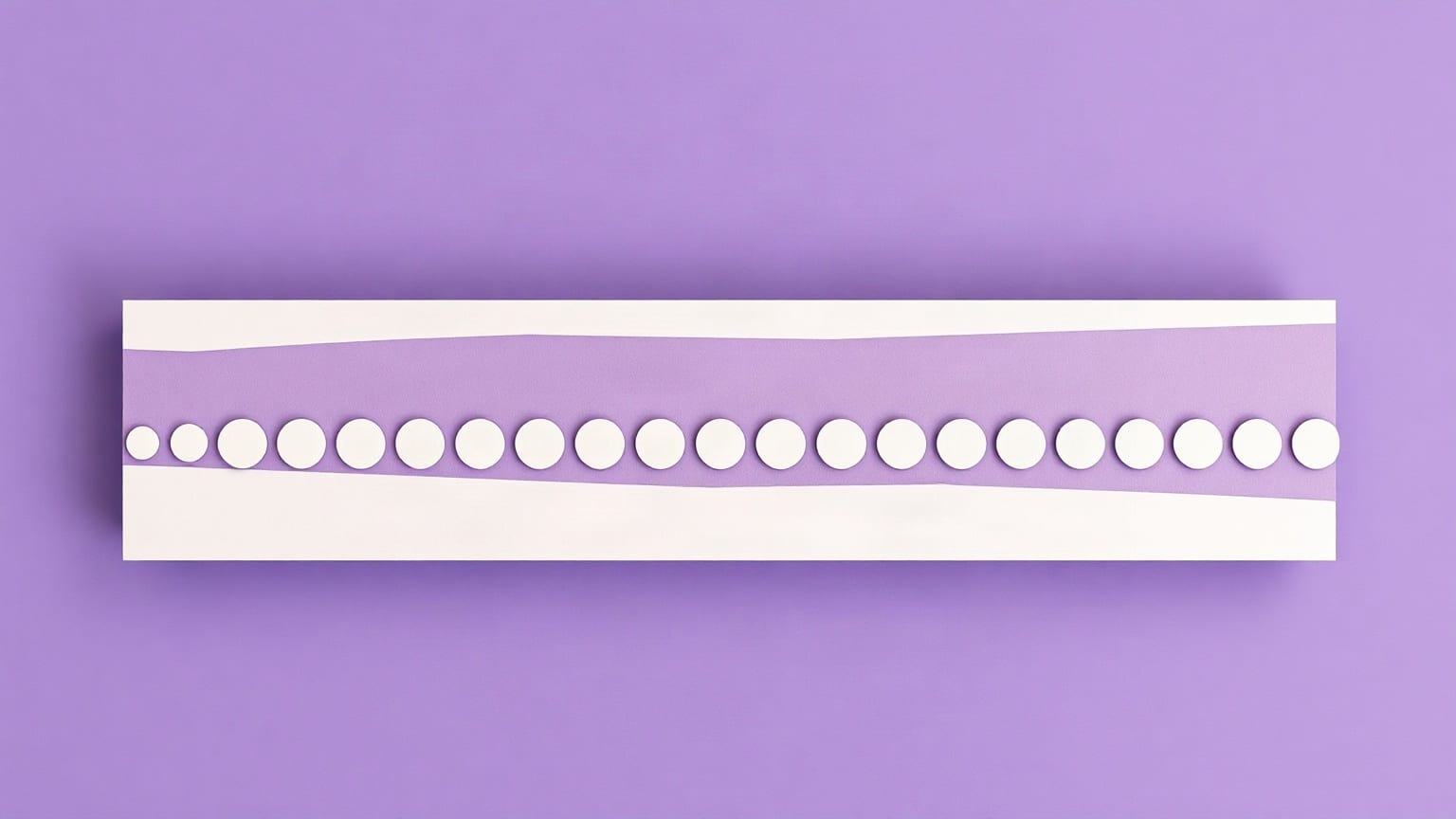 One long pale table slab running the full width of the frame seen from above, an even row of small cream discs down its length